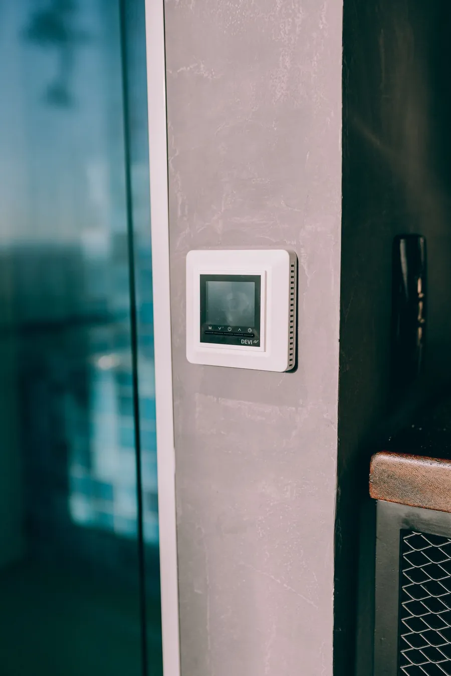 Digital thermostat on a wall, representing how we compared bed cooling systems